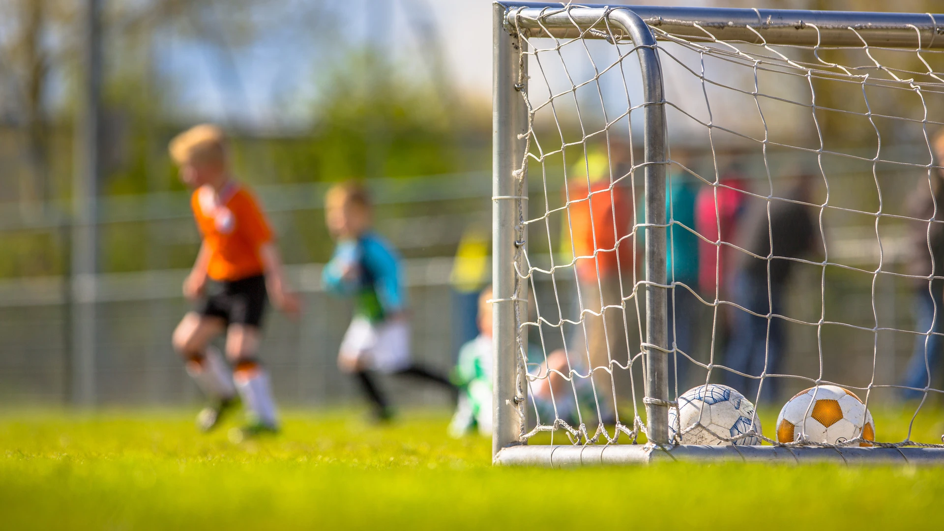 Kinder spielen Fußball und ein Tor ist zu sehen.