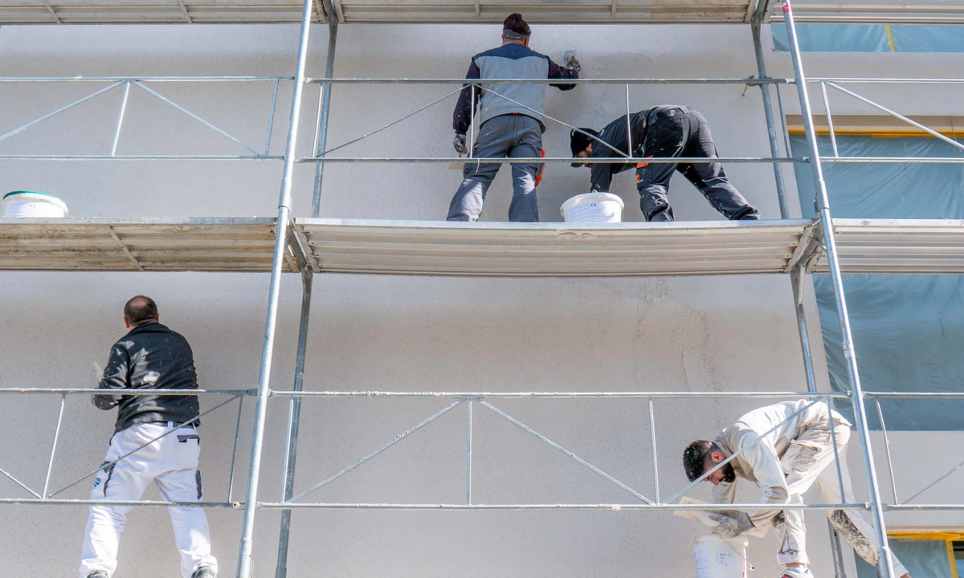 Viele Arbeiter auf dem Gerüst bei einer Baustelle