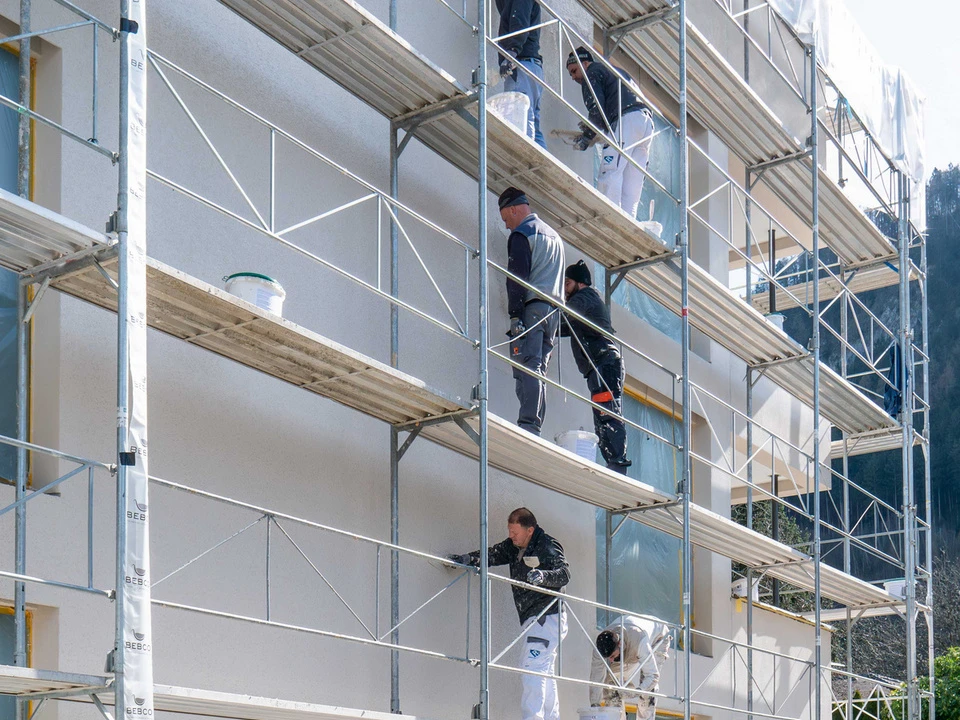 Gerüst auf einer Baustelle mit Verputzer bei der Arbeit